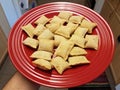 Hand holding red plate of frozen pizza rolls Royalty Free Stock Photo