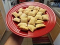 Hand holding red plate of frozen pizza rolls Royalty Free Stock Photo
