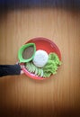 Hand Holding A Red Plate with Rice and Fresh Vegetables,  With Woody Texture Background Royalty Free Stock Photo