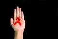 Hand holding red ribbon. Aids Awareness Sign Red Ribbon for World Aids Day concept . World Aids Day symbol for Aids campaigne - Royalty Free Stock Photo