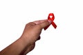 Hand holding red ribbon. Aids Awareness Sign Red Ribbon for World Aids Day concept . World Aids Day symbol for Aids campaigne - Royalty Free Stock Photo