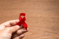 Hand holding red ribbon Aids awareness for World HIV/AIDS day Royalty Free Stock Photo
