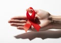 Hand holding red ribbon symbolizing awareness Royalty Free Stock Photo
