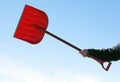 Hand holding red snowshovel Royalty Free Stock Photo