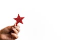 Hand holding a red star & x28;Christmas ornament& x29; against the white background Royalty Free Stock Photo