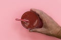 Hand holding red strawberry smoothie drink pink background Royalty Free Stock Photo