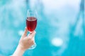 Hand holding red wine glass in pool Royalty Free Stock Photo