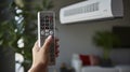 Hand holding the remote control aimed at air conditioner. Generative AI Royalty Free Stock Photo