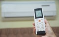 Hand holding remote control for open air conditioner Royalty Free Stock Photo