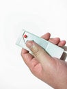 Hand Holding Remote Control Pressing Button on White Background Royalty Free Stock Photo