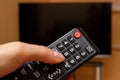 Hand holding remote control for television, choosing channel in TV Royalty Free Stock Photo