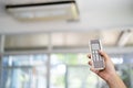 The hand that is holding the remote to control the air conditioner Royalty Free Stock Photo