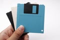 Hand holding retro vintage floppy disk diskettes on white, old time computer storage equipment hardware Royalty Free Stock Photo