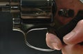 Hand holding revolver gun and finger pulling on trigger to shoot black background Royalty Free Stock Photo