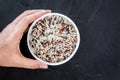 Hand holding rice in a bowl on black background Royalty Free Stock Photo