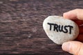 Hand-holding rock with handwritten word \