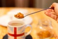 Hand holding rock sugar with coffee cup on table.