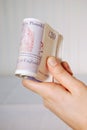 Hand holding a roll of twenty pound notes Royalty Free Stock Photo