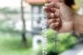 Hand holding rosary beads with Jesus Christ holy cross crucifix. Praying rosary and believe in God concept. Catholic symbol.