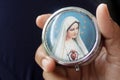 Hand holding and showing portrait of Mother Virgin Mary on the front rosary box cover. Royalty Free Stock Photo