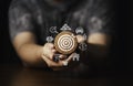 Hand holding round wooden with white dartboard and business icon include gold bar , car , dollar ,house and piggy saving for setup