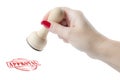 Hand holding a rubber stamp with the word approval