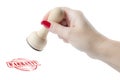 Hand holding a rubber stamp with the word warranty