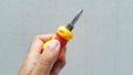 Hand holding short screwdriver with phillips head on white background Royalty Free Stock Photo