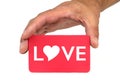 Hand holding and showing a red card with LOVE text and heart shape