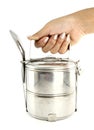 A hand holding silver metal tiffin