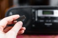 Hand holding silver USB flash drive connected to audio system or tape recorder. Royalty Free Stock Photo