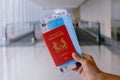 Hand holding SINGAPORE passport, with face mask and boarding pass in airport Royalty Free Stock Photo
