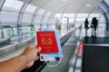 Hand holding Singapore passport walking on travelator, travolator moving walkway Royalty Free Stock Photo