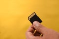 Hand holding a single Black SD Card for camera isolated background Royalty Free Stock Photo