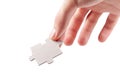 Hand holding a single blank empty jigsaw puzzle piece, laying, putting down from above gesture isolated on white, cut out. Fingers Royalty Free Stock Photo
