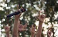 hand holding a single microphone against colourful background,singing contest. Royalty Free Stock Photo