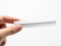 A hand holding a single white rectangular object against a white background Royalty Free Stock Photo