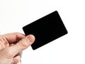 A hand holding a sleek black rectangular object against a white background Royalty Free Stock Photo