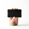 A hand holding a sleek black smartphone or tablet against a plain background Royalty Free Stock Photo
