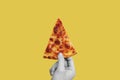 Hand holding slice of Classic cheese pizza, on yellow background Royalty Free Stock Photo