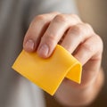The background is blurred, emphasizing focus on the cheese and the hand Royalty Free Stock Photo