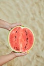 Hand Holding a Slice of Watermelon on a Sunny Beach Day Royalty Free Stock Photo
