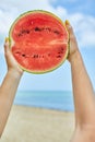 Hand Holding a Slice of Watermelon on a Sunny Beach Day Royalty Free Stock Photo