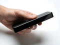 A hand holding a small black rectangular object Royalty Free Stock Photo