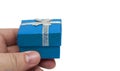 Hand holding small blue gift with silver ribbon Royalty Free Stock Photo