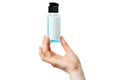 Hand holding small bottle with blue sanitizing liquid