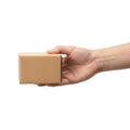 A hand holding a small brown cardboard box against a plain background Royalty Free Stock Photo