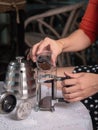 Hand holding small cup of ground coffee and pouring into a jar Royalty Free Stock Photo