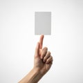 A hand holding a small, floating, rectangular, white object against a plain background Royalty Free Stock Photo