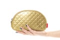 Hand holding a small golden purse. Close up. Isolated on a white background Royalty Free Stock Photo